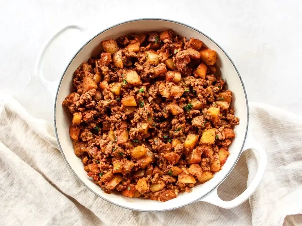 A top view of ground turkey cooked with potato inside a white pot