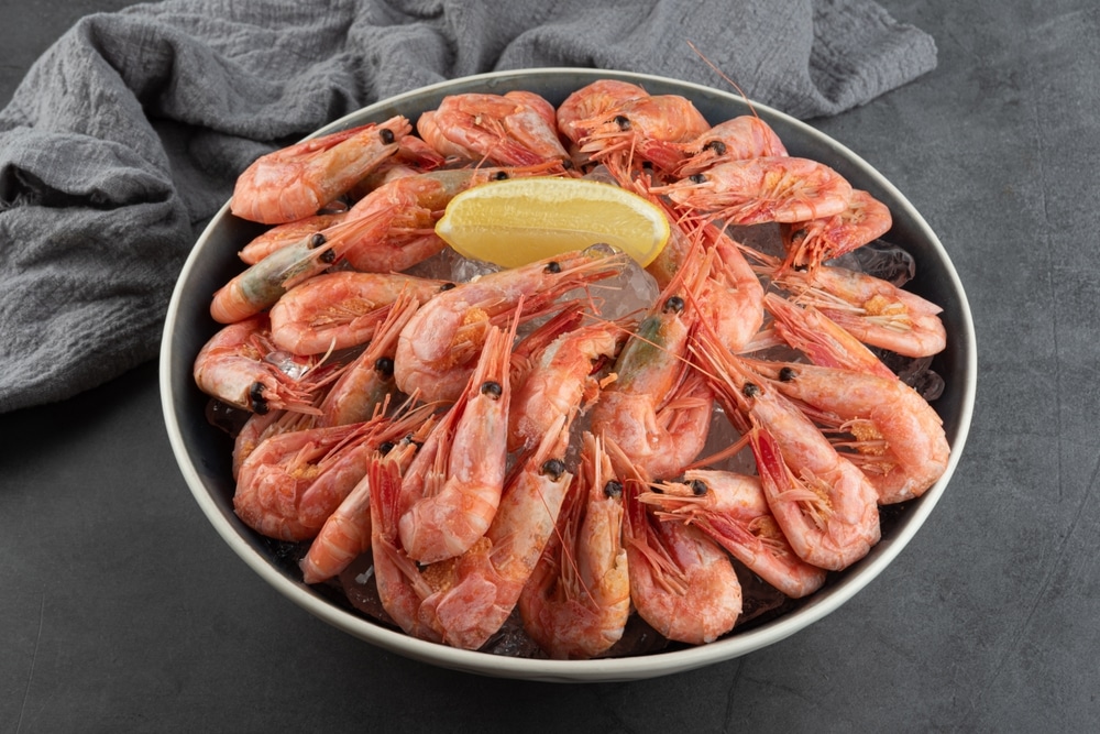 Boiled Shrimp On A Black Plate With Ice And Lemon