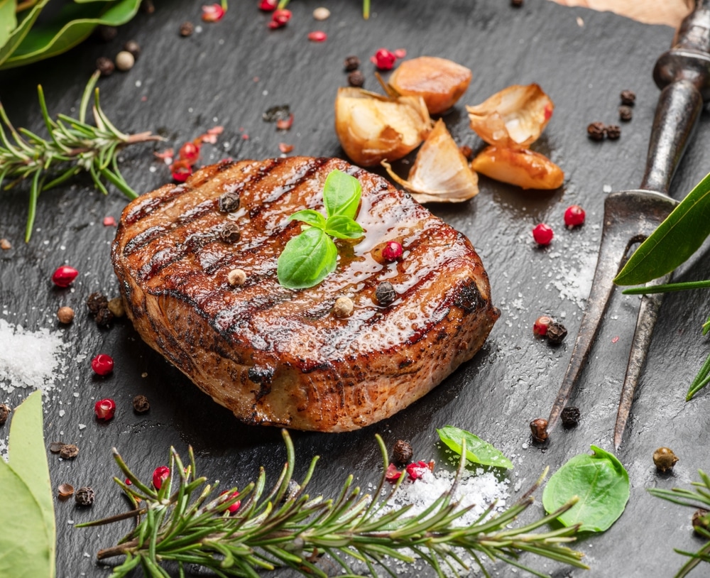 Grilled Delicious Ribeye Steak And Some Seasonings And Herbs On