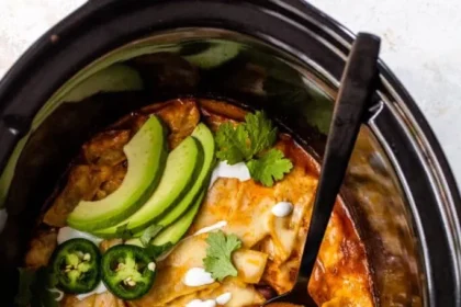 Slow Cooker Chicken Enchiladas garnished with green chillies and cilantro