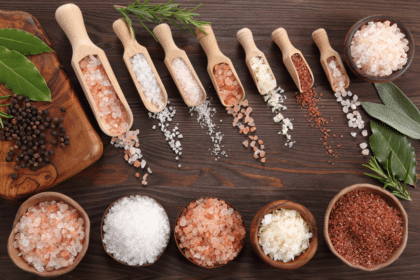 Various types of salt on wooden spoons and in bowls Top view