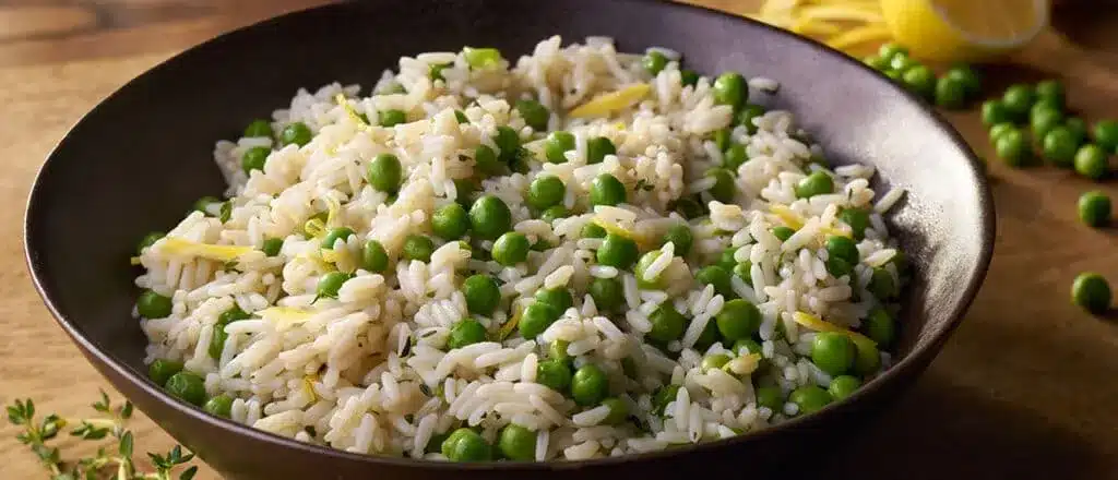 a bowl of rice cooked in chiken broth with peas