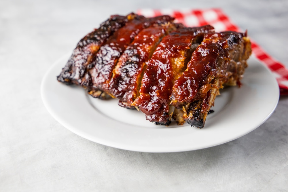 Oven baked barbecue ribs with sauce on a white plate