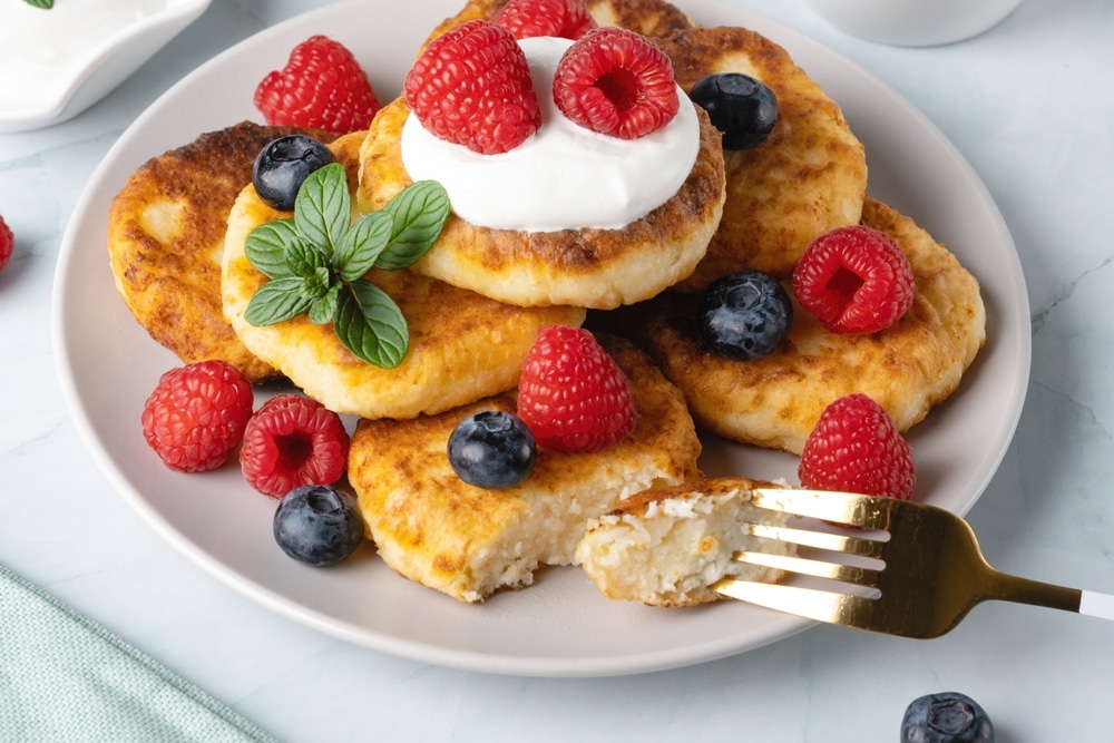 Cottage Cheese Pancakes With Raspberries And Blueberry On Light Background